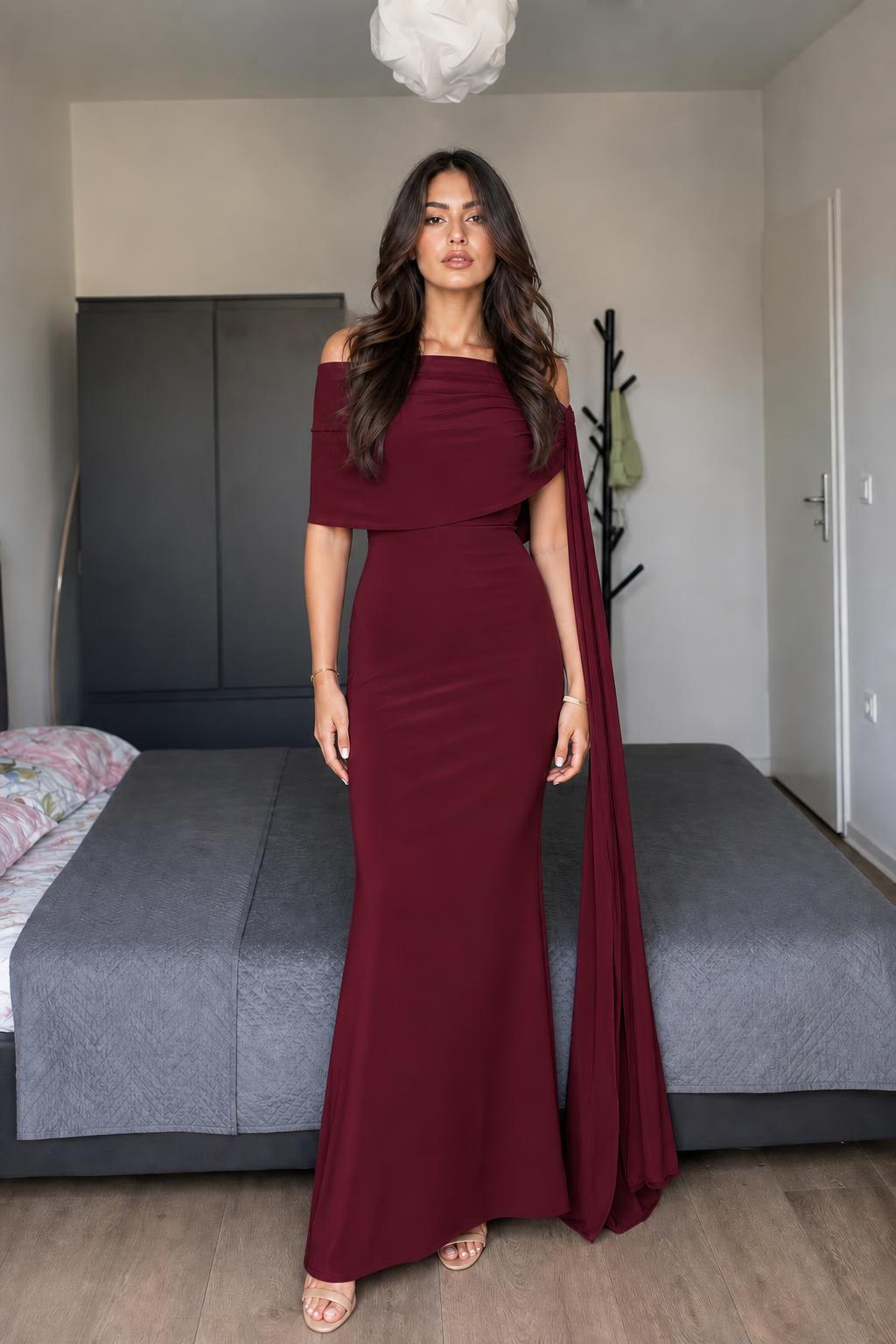 Model wearing burgundy off-shoulder cape maxi dress