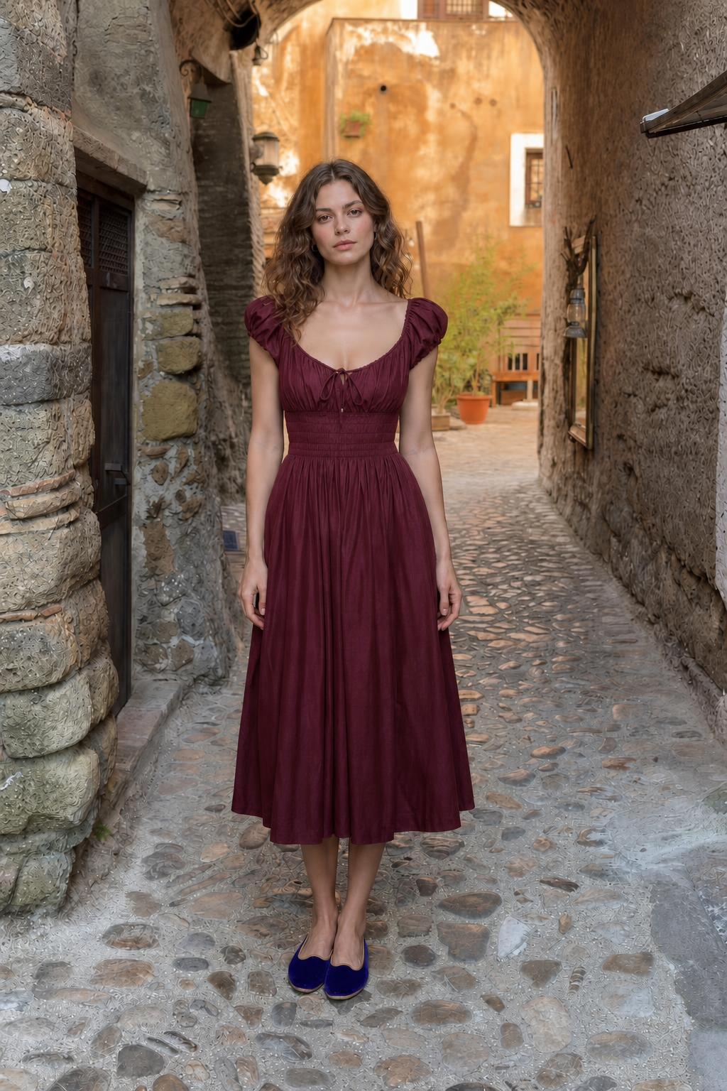 Front view of woman wearing burgundy smocked midi dress