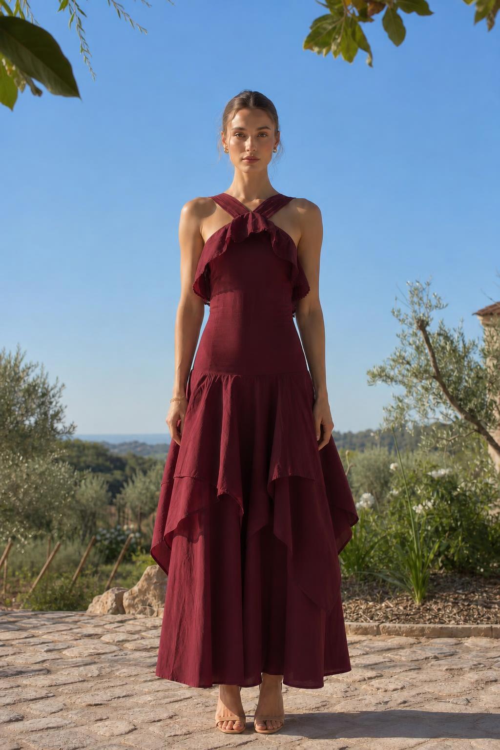 Front view of woman wearing burgundy halter neck ruffled maxi dress