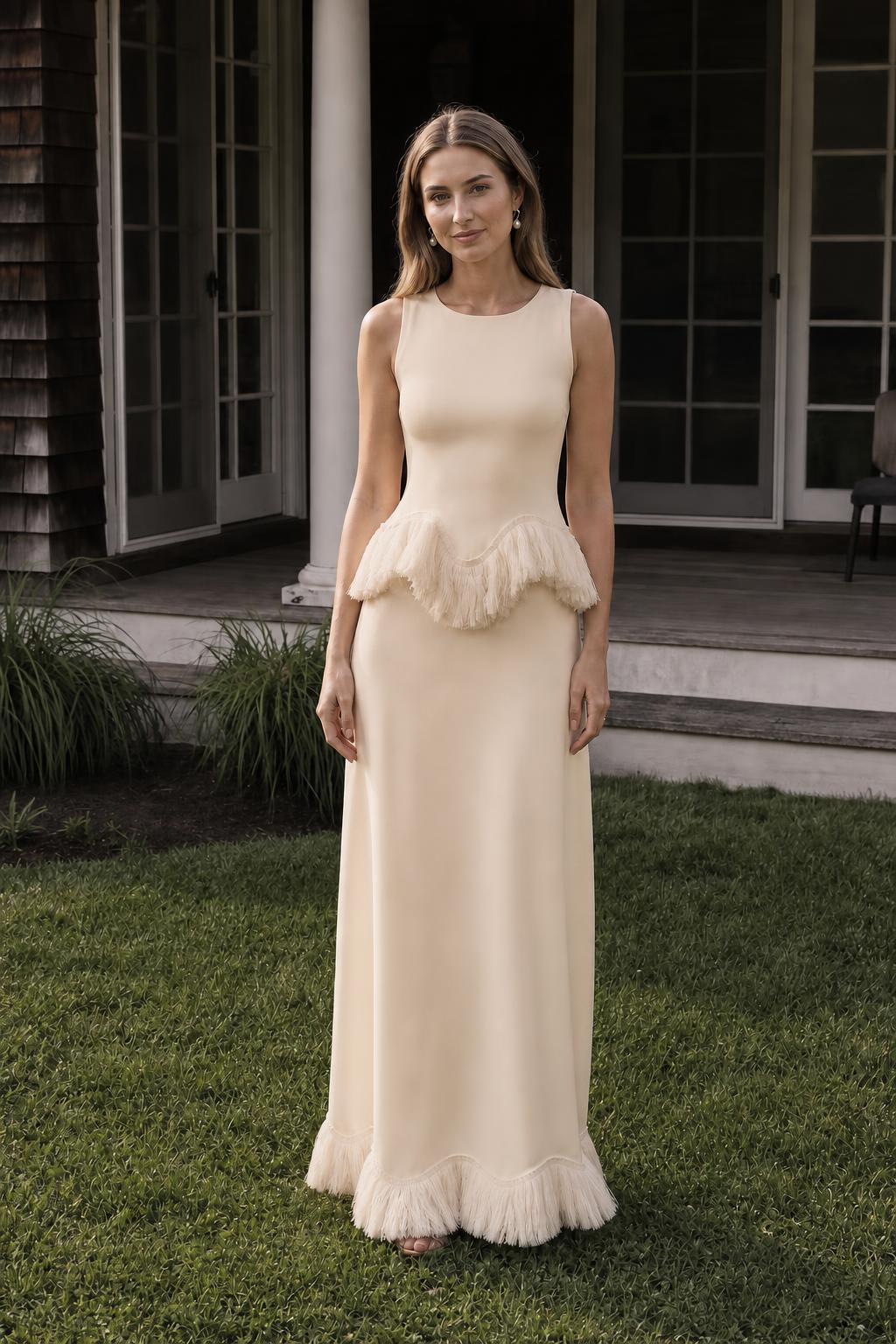 Front view of model wearing champagne fringed peplum maxi dress