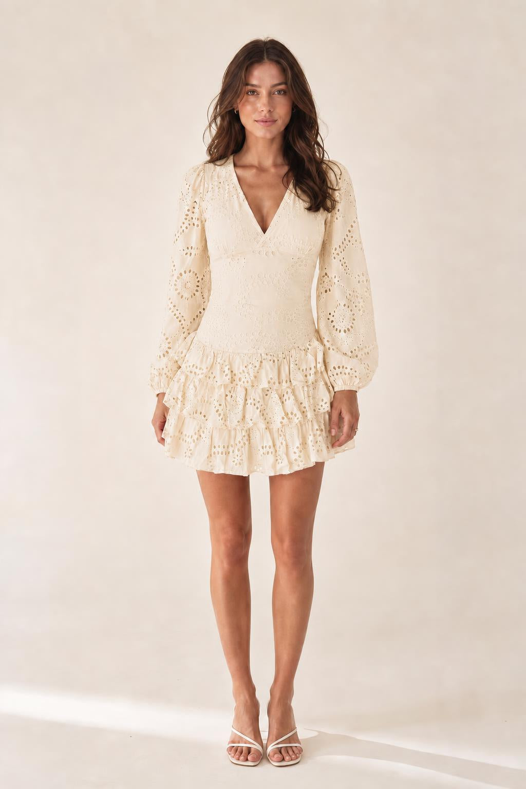 Front view of model wearing cream eyelet mini dress